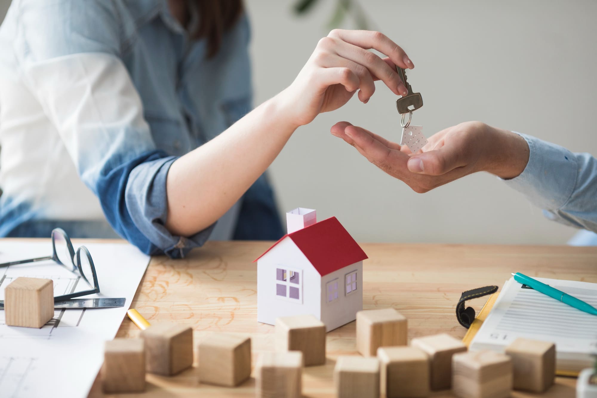 hand giving house key to man